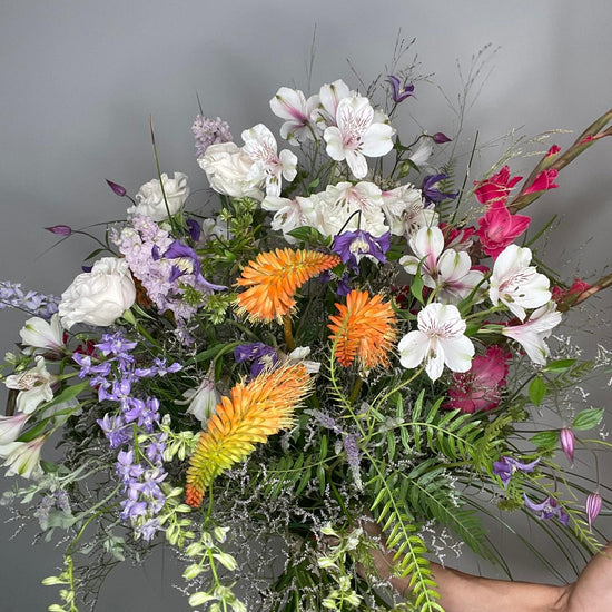 Botanical Rhapsody — ramo silvestre con kniphofia naranja, alstroemeria blanca y gladiolos fucsia