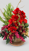 Centro navideño en cesta con amarilis rojas, protea, cardos dorados, piñas, bayas rosas y ramas de pino