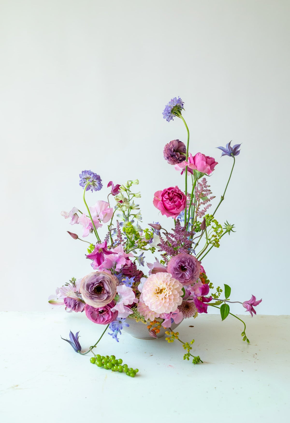 Composición floral en jarrón con dalia, ranúnculos morados y escabiosa, estilo orgánico