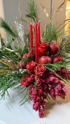 Composición navideña con velas rojas, rosas rojas escarchadas, granadas, bayas rojas, ramas de pino y guirnalda dorada