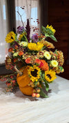 Composición otoñal en calabaza con girasoles, rosas naranjas, crisantemos, amaranto, bayas y manzanas ornamentales