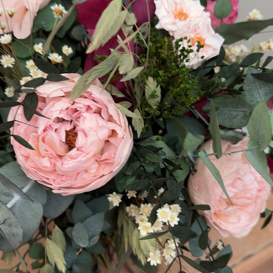 Detalle de ramo con rosas rosas y burdeos, manzanilla y eucalipto