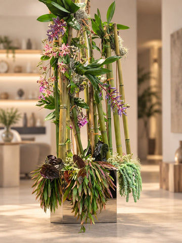 Arreglo floral con tallos de bambu y orquideas en maceta metalica cuadrada