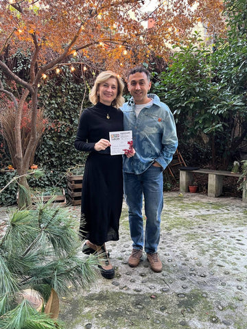 Pareja con certificado en jardín con luces y árboles otoñales