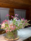 Pink Reverie — composición con protea rosa, orquídeas cymbidium y nerina fucsia