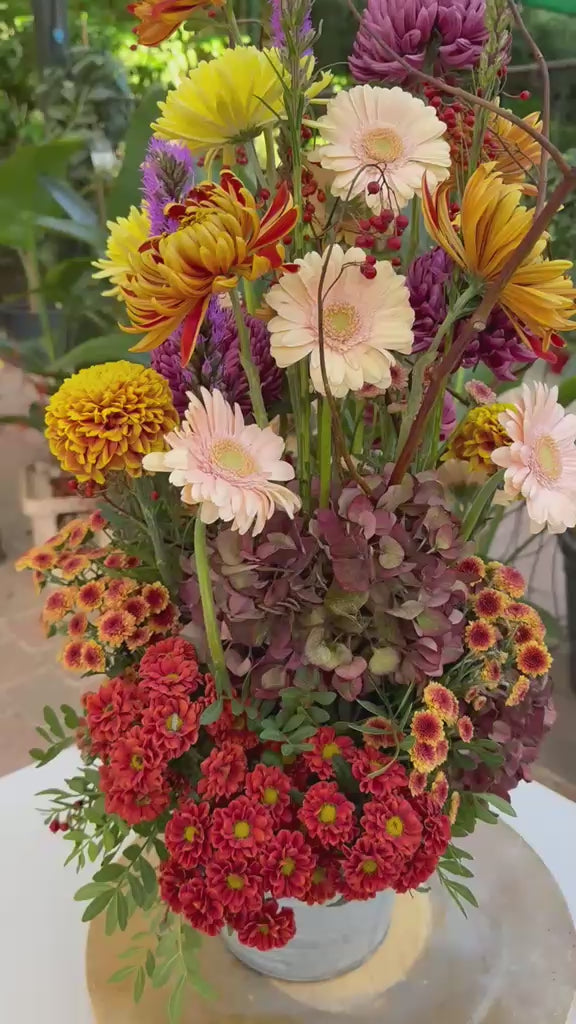 Vídeo de ramo otoñal con gerberas crema, crisantemos naranjas y amarillos, hortensias, liatris y bayas rojas