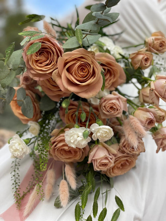 Detalle de ramo de novia con rosas capuchino, claveles blancos, lagurus rosa y eucalipto