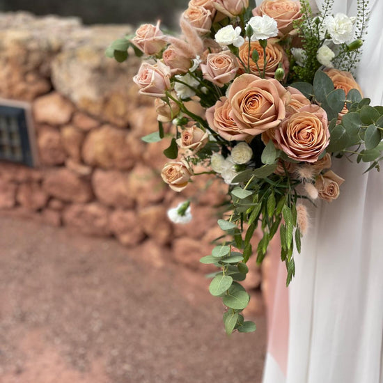 Vista lateral de ramo de novia con rosas capuchino, claveles blancos, lagurus y eucalipto
