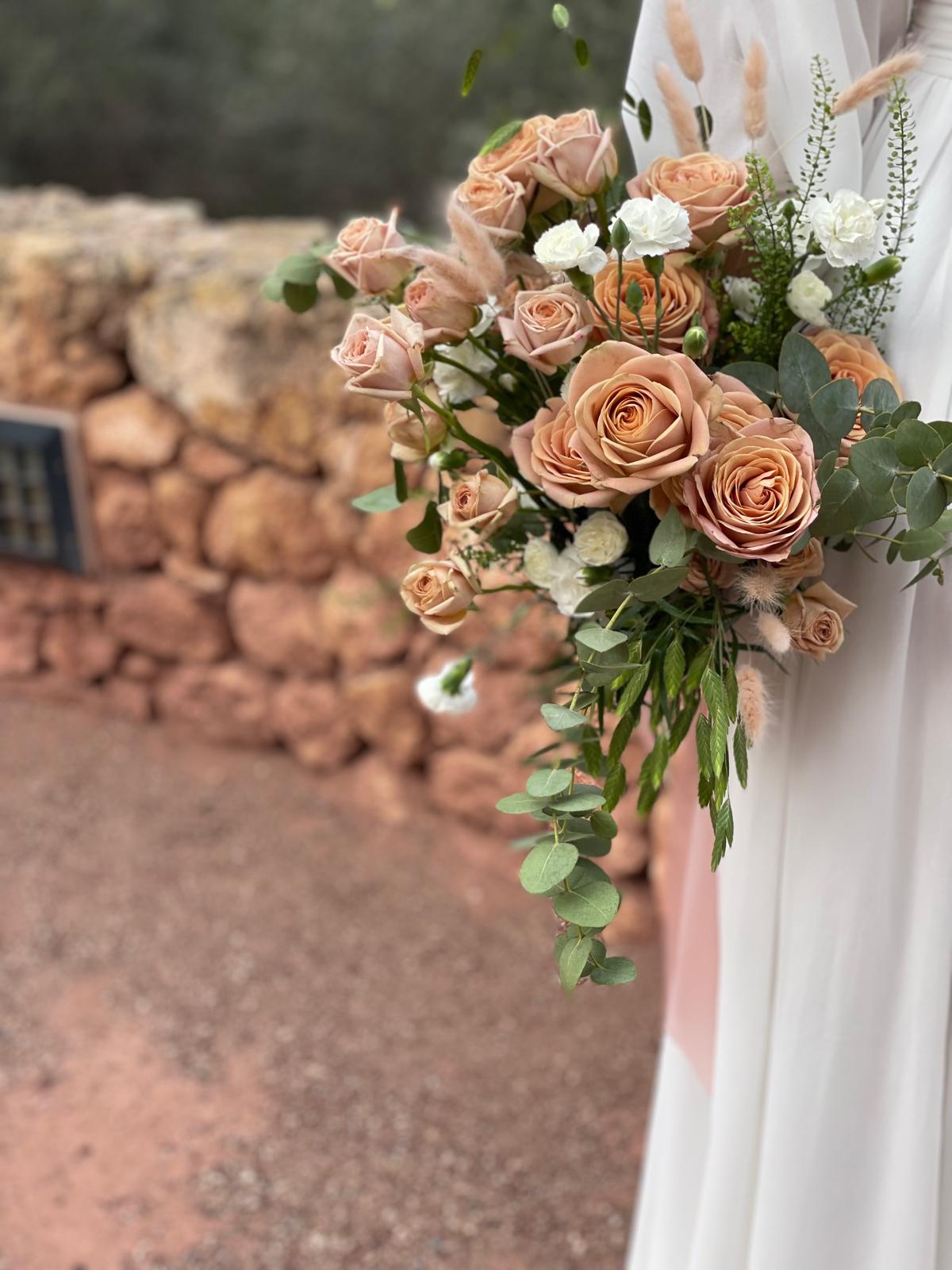 Vista lateral de ramo de novia con rosas capuchino, claveles blancos, lagurus y eucalipto
