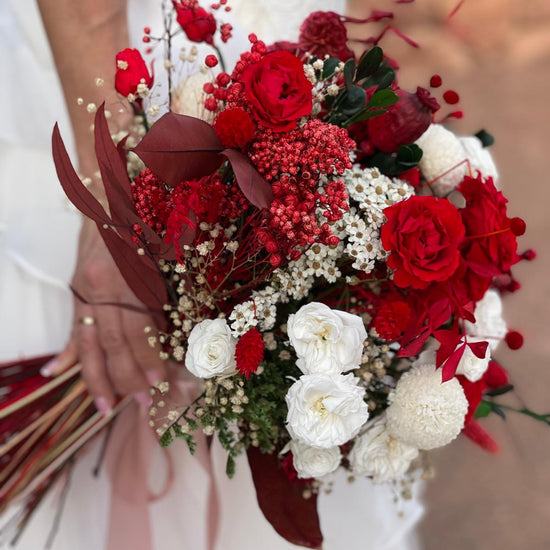 Ramo de novia con rosas rojas y blancas, flores silvestres y follaje bordó