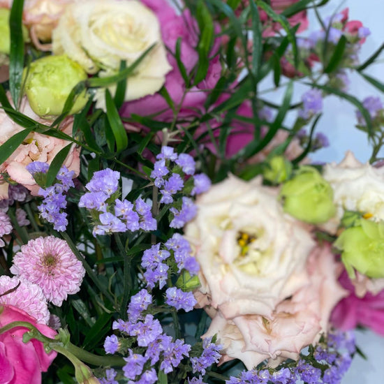 Detalle de ramo con lisianthus crema y verde, limonium lila, crisantemo rosa y peonías fucsia