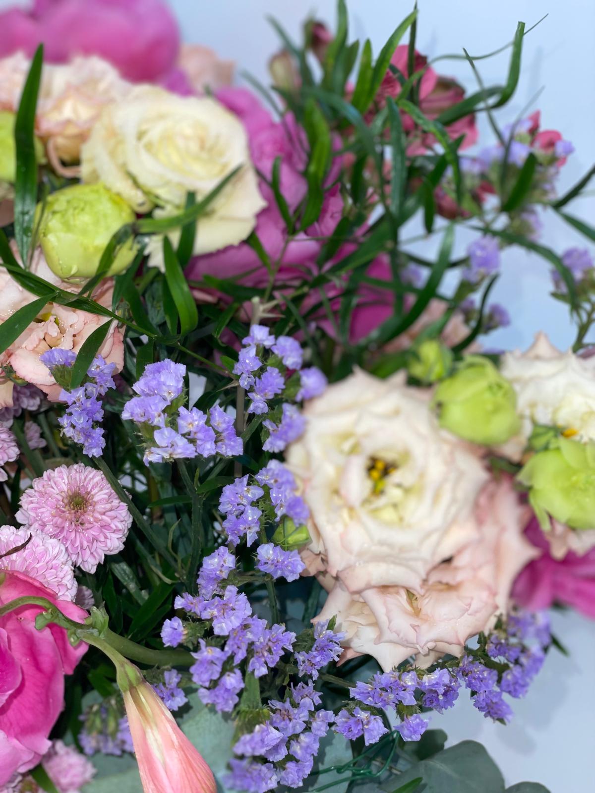 Detalle de ramo con lisianthus crema y verde, limonium lila, crisantemo rosa y peonías fucsia