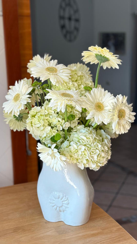 Ramo de gerberas blancas con hortensias verde claro y crisantemos verdes en jarrón de cerámica blanca