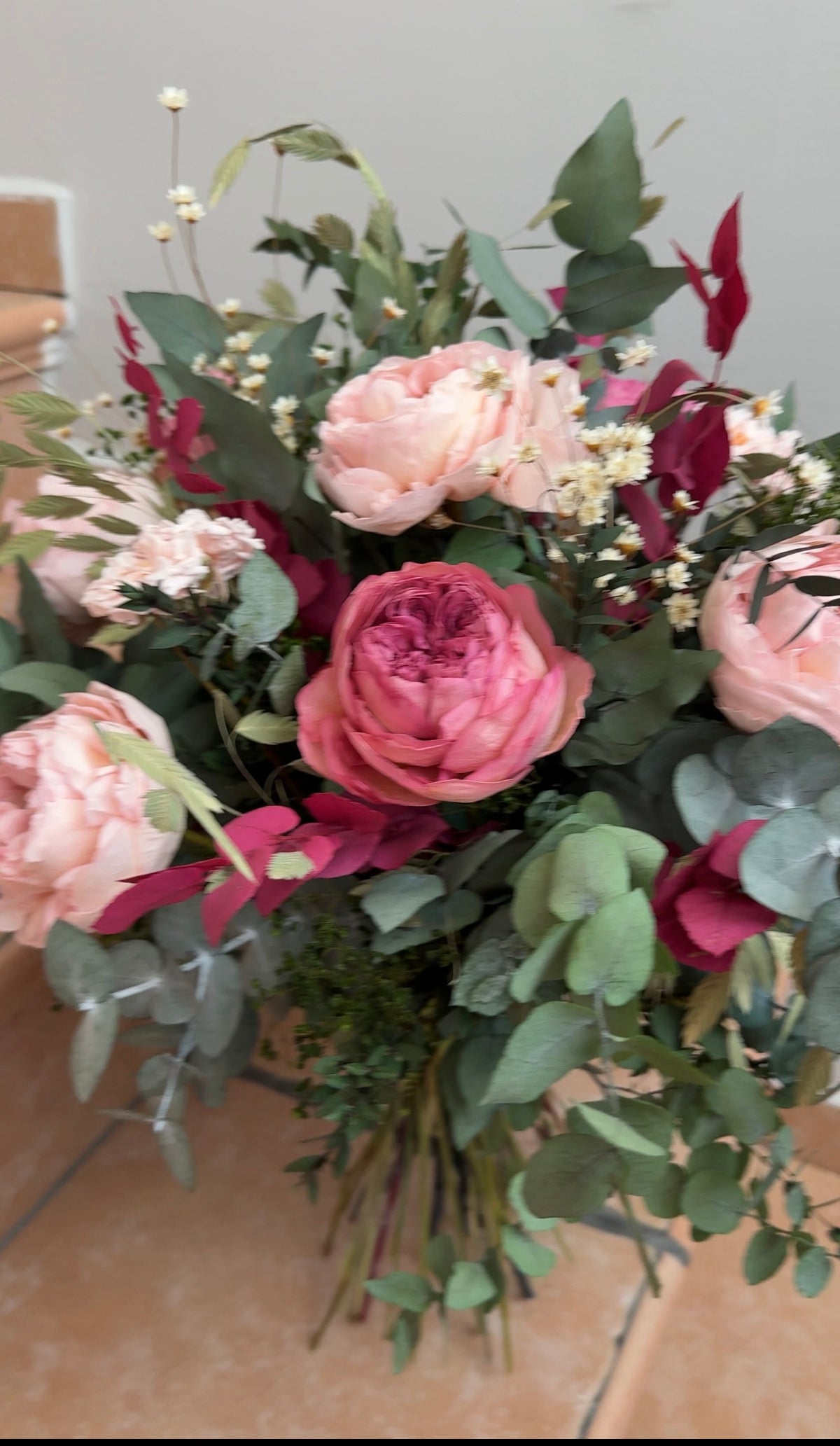 Ramo de rosas rosas y burdeos con manzanilla silvestre y eucalipto verde