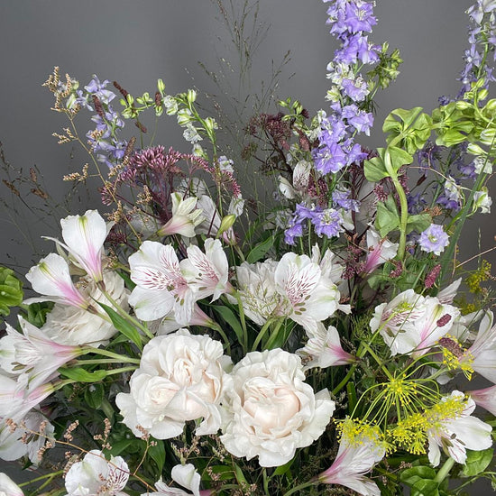 Wild Poetry — primer plano de rosas blancas y delphinium lila